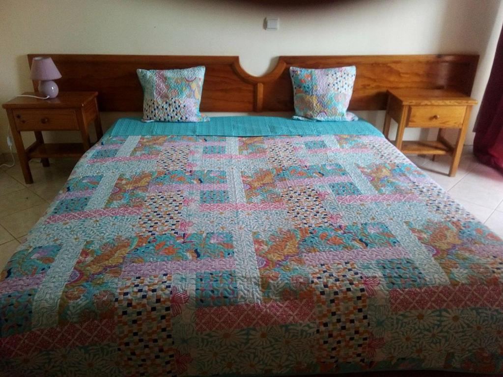 a bed with a colorful quilt on top of it at Solmar apartment in Beirona