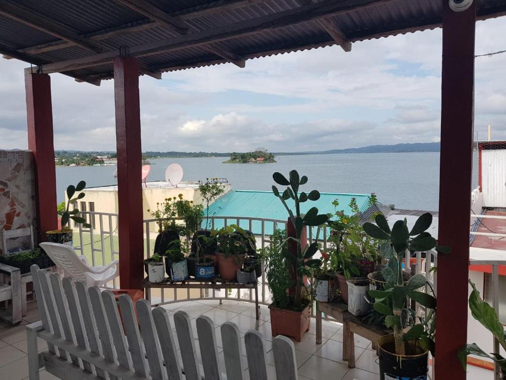 a balcony with potted plants and a view of the water at Hotel Posada Tayazal in Flores