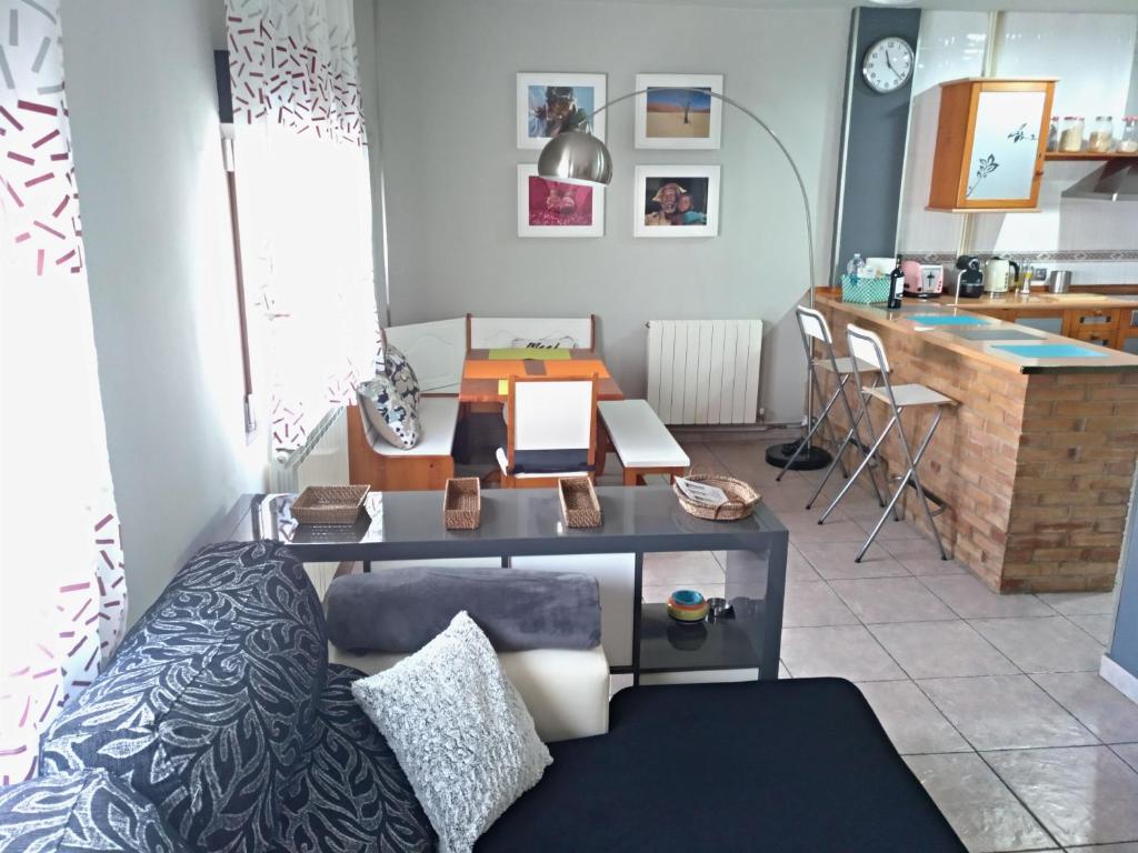 a room with a desk with a bed and a kitchen at Piso La Torre in Zaragoza