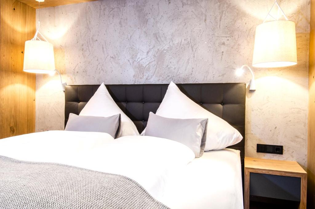 イシュグルにあるHotel Garni Funtanaのベッドルーム(白いベッド、白い枕付)