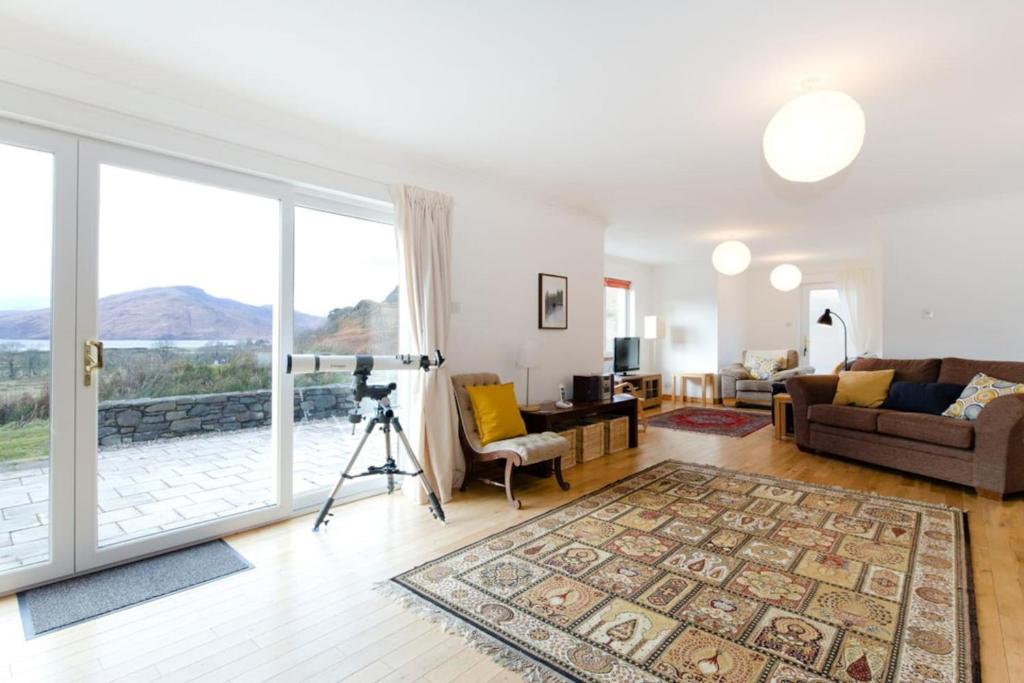 un soggiorno con una grande finestra e una macchina fotografica di Skye View a Glenelg
