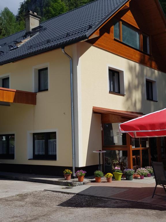 un edificio con un paraguas rojo delante de él en Seeblick Krippenstein, en Obertraun