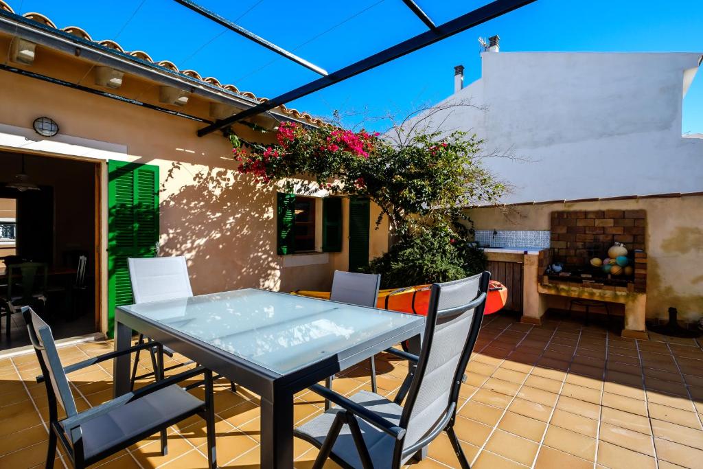 una mesa y sillas en un patio con chimenea en Casa Mar a 2 MIN de la Playa Son Serra de Marina, en Son Serra de Marina