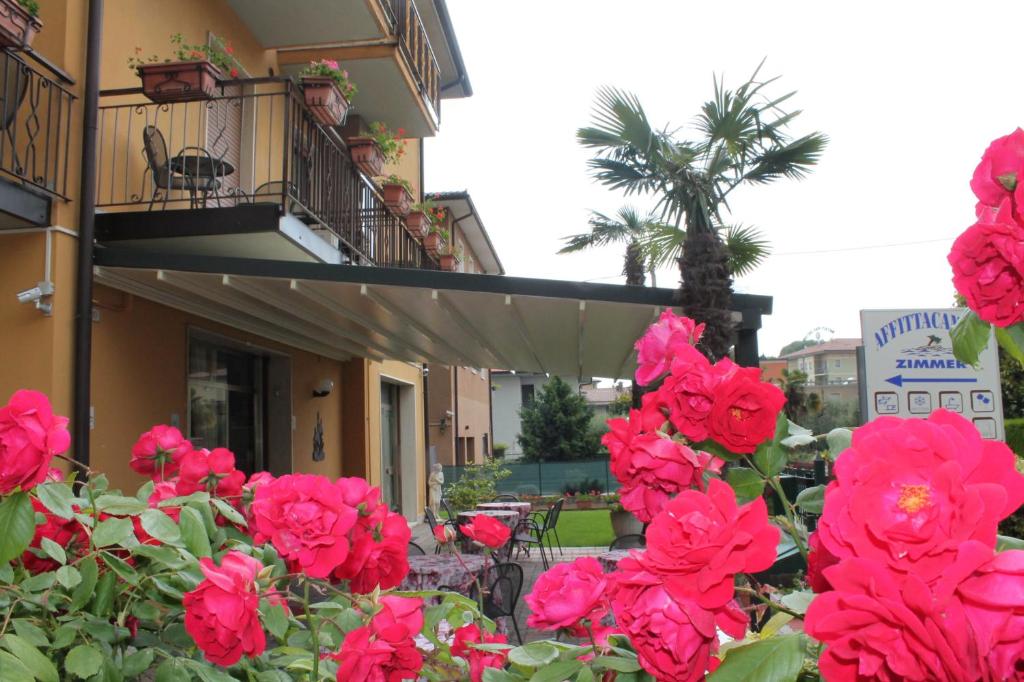 a group of red roses in front of a building at Alessio Camere in Bardolino