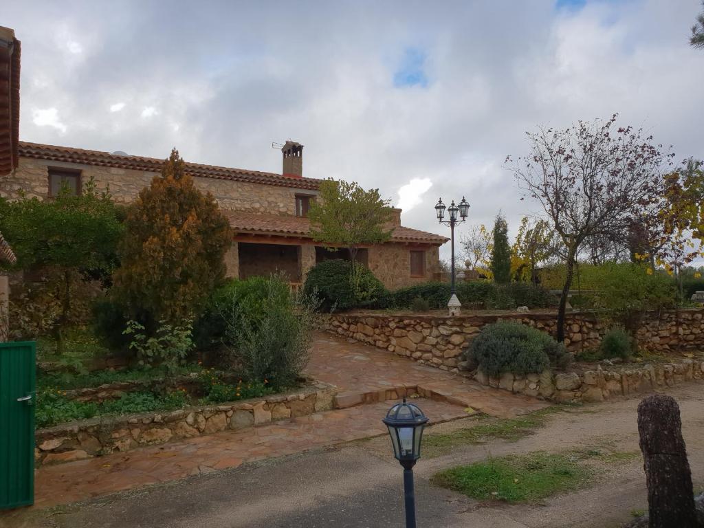 una casa con una pared de piedra y una luz de la calle en Casa Rural Barba, en Fuente-Higuera