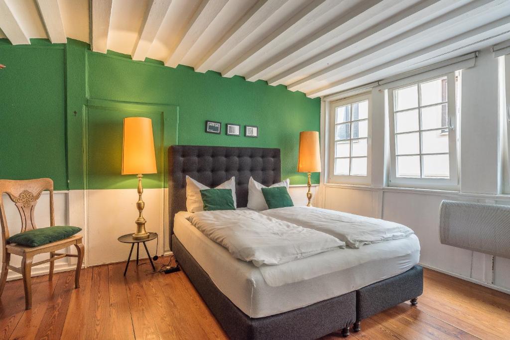 1 dormitorio con 1 cama con pared verde en Apartment Zentral im Herzen der Altstadt, en Tübingen