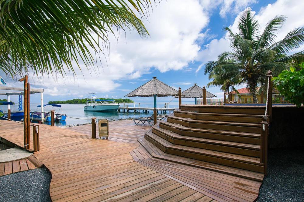 Dixon Cove的住宿－Wikkid Resort，木甲板上设有楼梯,水中设有船只