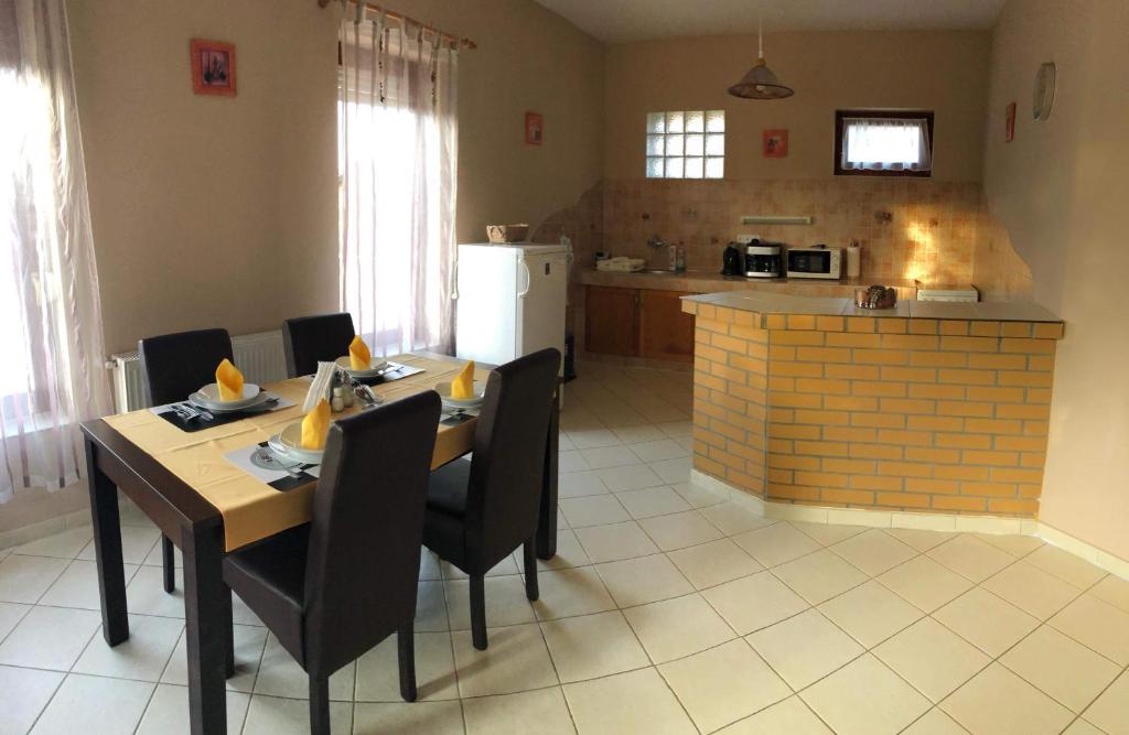 a kitchen with a wooden table and chairs and a kitchen with at Kristály Apartmanház in Sárvár