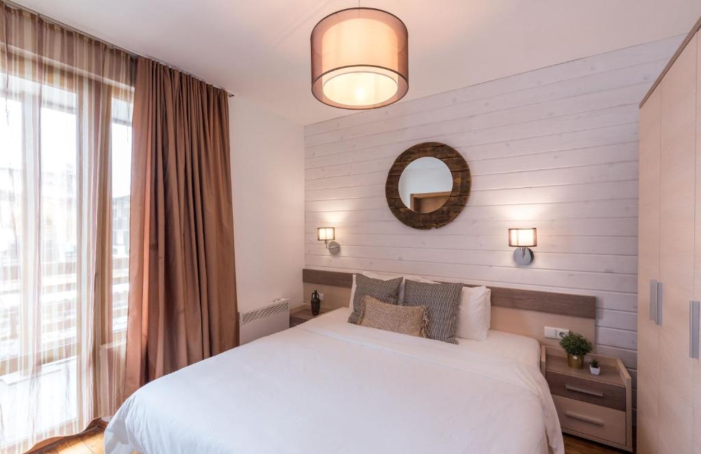 una camera con letto bianco e specchio di ★ Chic & Elegant 1 Bedroom in Eagle's Nest Complex ★ Close to Gondola and Bar Street a Bansko