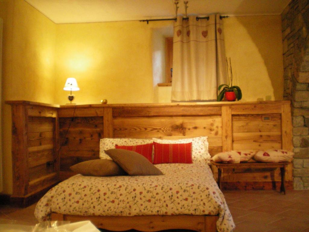 una camera da letto con un letto con cuscini sopra di Au Coeur a Verrayes