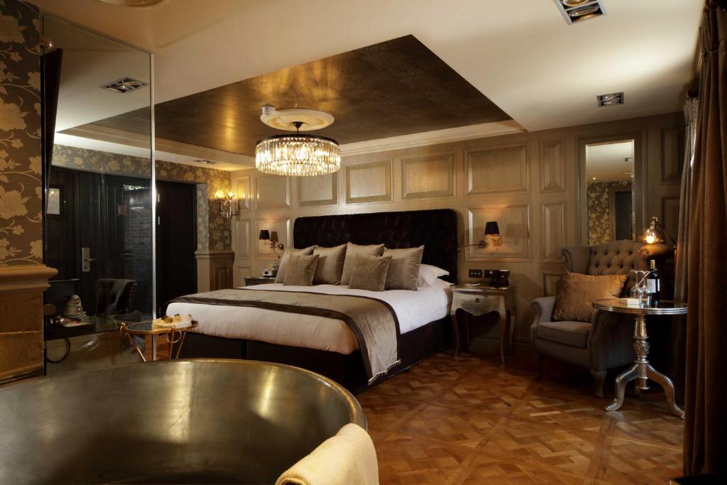 a hotel room with a large bed and a large mirror at The Impeccable Pig in Sedgefield