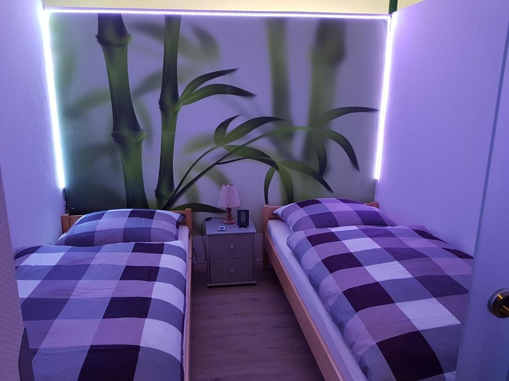 een kamer met twee bedden en een plant aan de muur bij Ferienwohnung Bambus in Winterberg