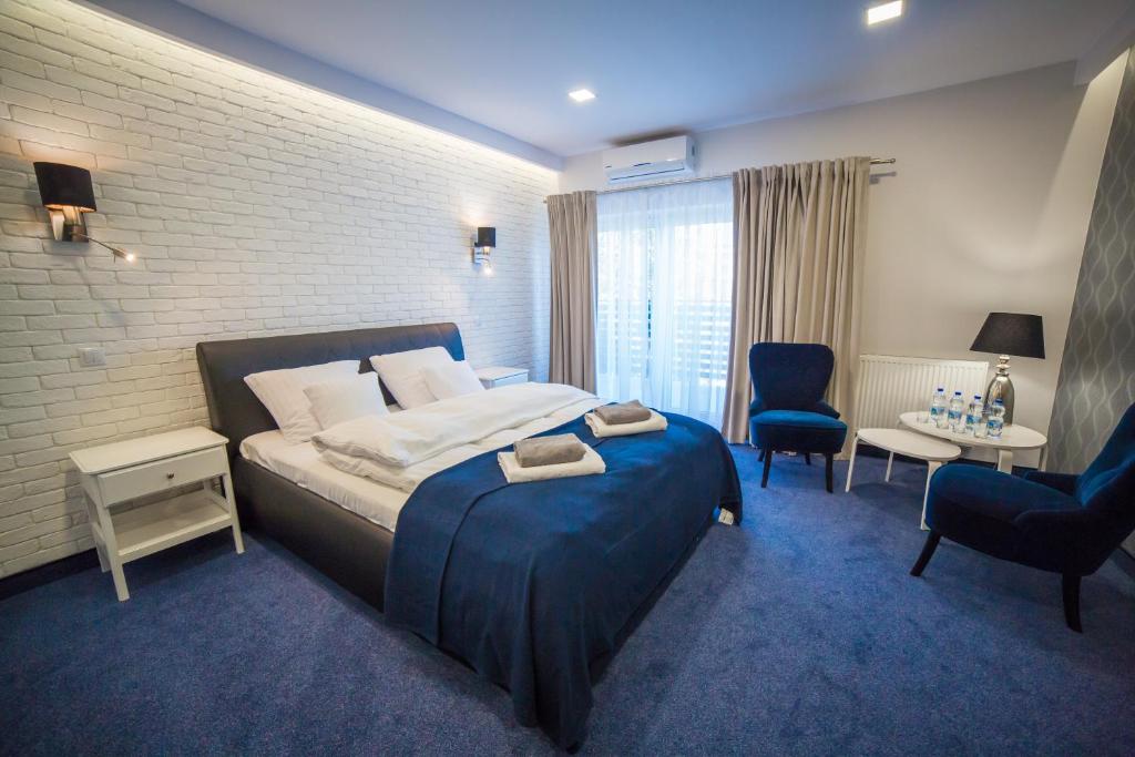 sypialnia z dużym łóżkiem z niebieskim dywanem w obiekcie Pensjonat Augustyniak w mieście Ostrołęka