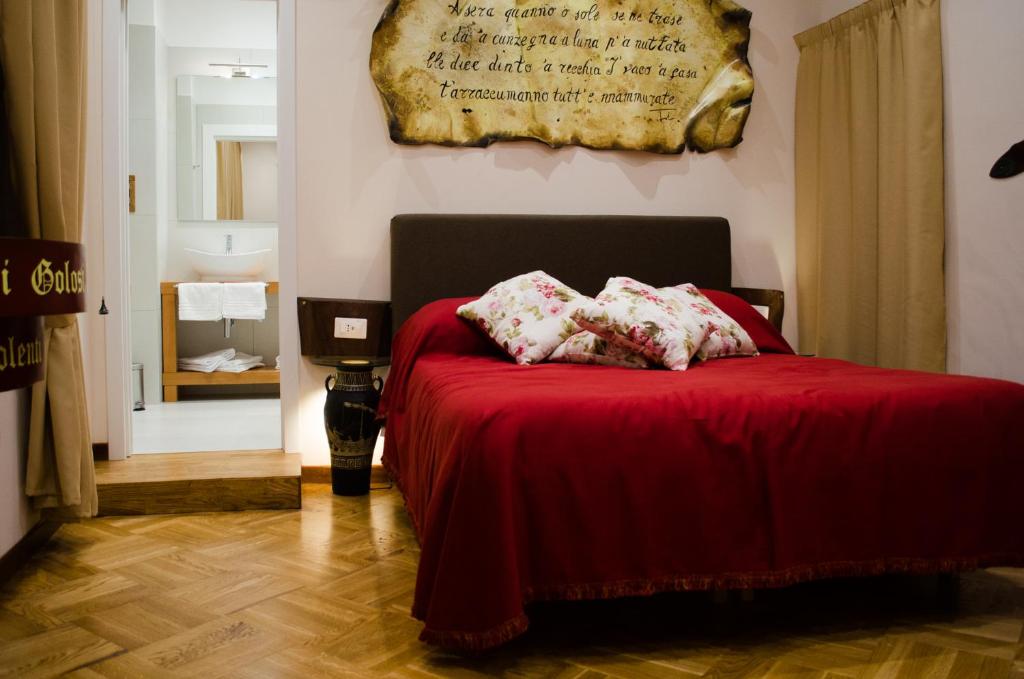 um quarto com uma cama vermelha com duas almofadas em B&B Sosta Flegrea em Nápoles