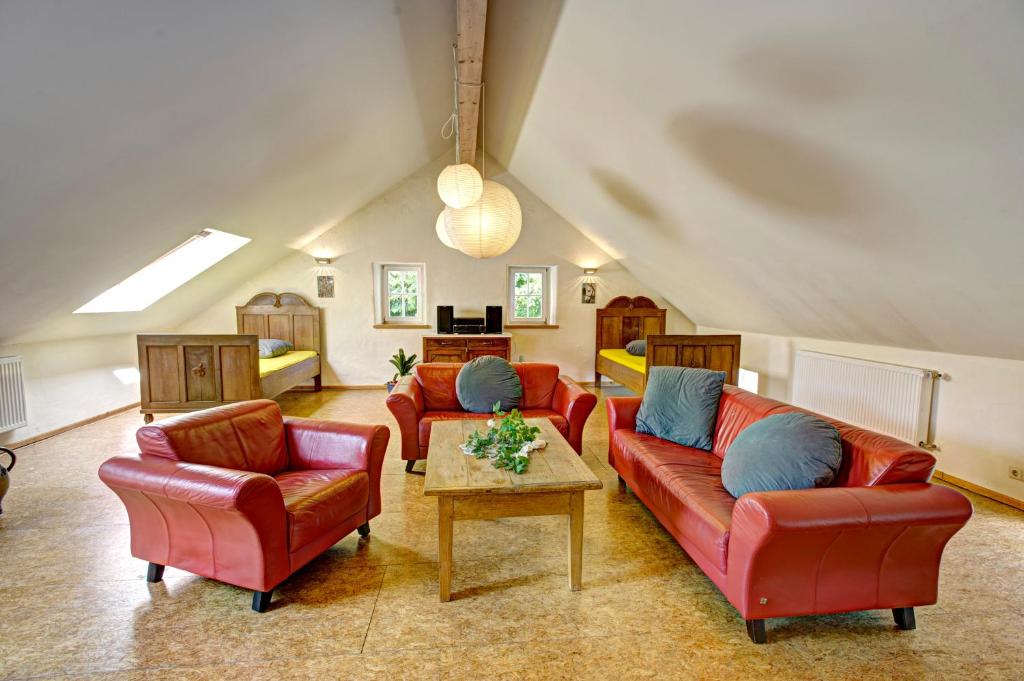 una sala de estar con sofás rojos y una mesa. en Ferienhaus Königskerze, en Wißmannsdorf
