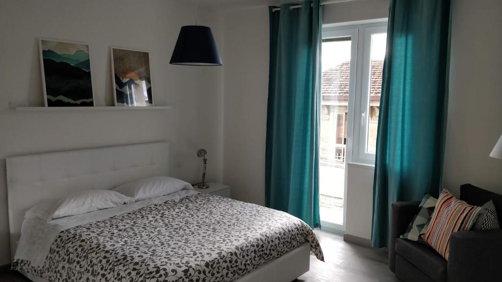 坎波巴索的住宿－Novantatrè，一间卧室配有一张带蓝色窗帘的床和一扇窗户