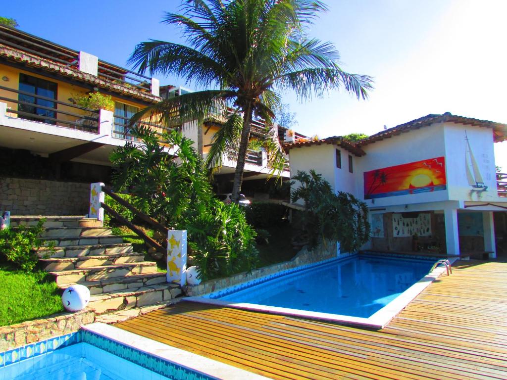 una casa con piscina al lado de un edificio en Flat Geribá com linda vista, 500 metros da praia, en Búzios