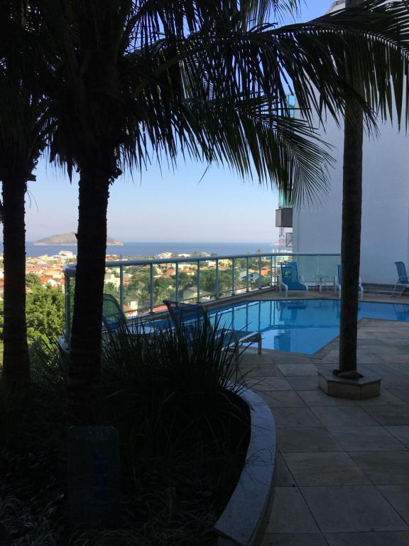 a swimming pool with a view of the ocean at Apartamento linda vista, 200 metros da praia de camboinhas in Niterói