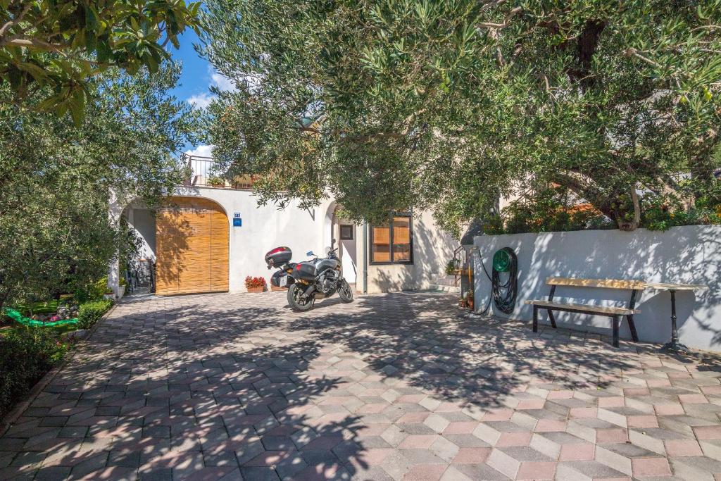 a motorcycle parked in a driveway next to a building at Apartments Josip in Makarska