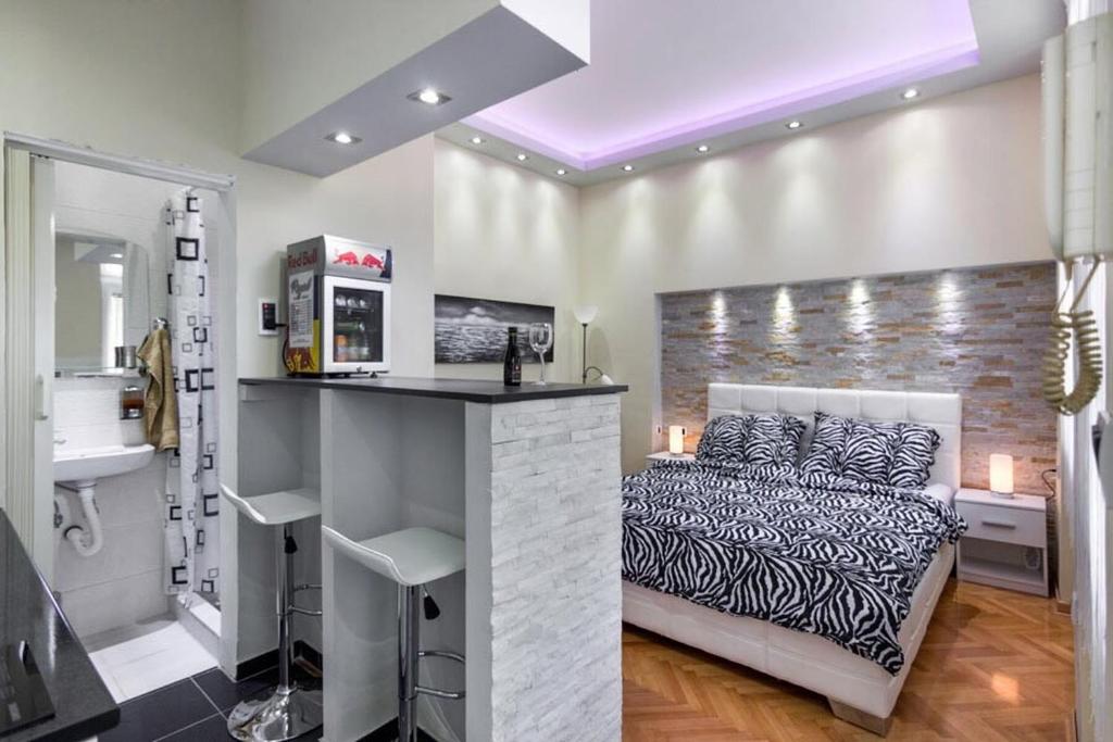 1 dormitorio con 1 cama y barra con fregadero en Apartment Royal, en Belgrado