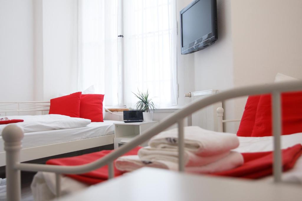 a hospital room with two beds with red pillows at Gästehaus City Stop Berlin in Berlin