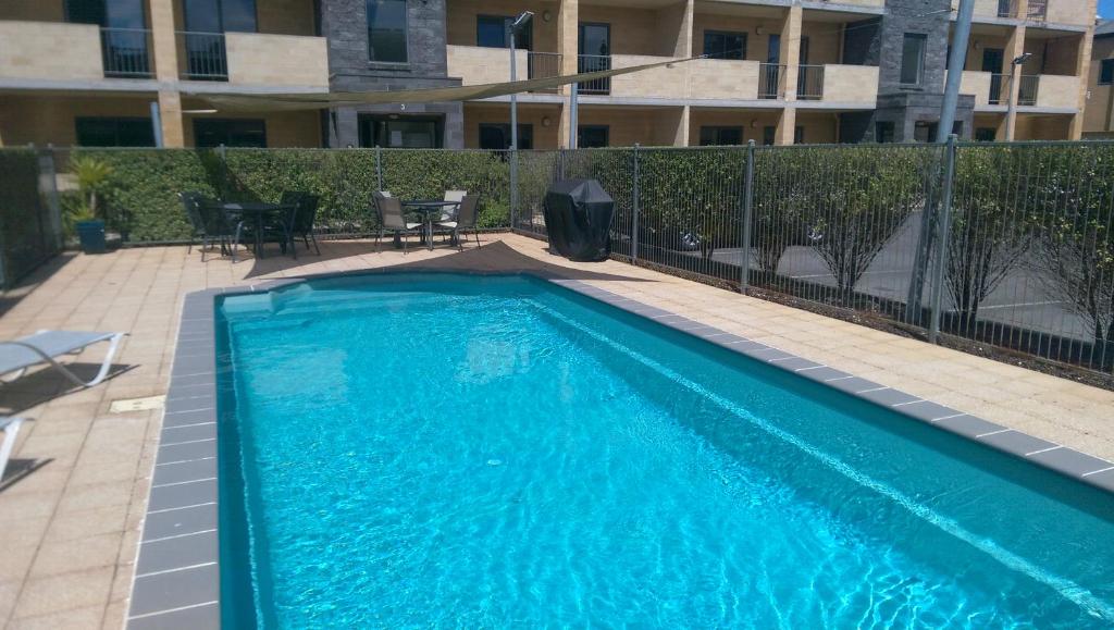 a large blue swimming pool in front of a building at 22 Gillies Street Apartments in Warrnambool