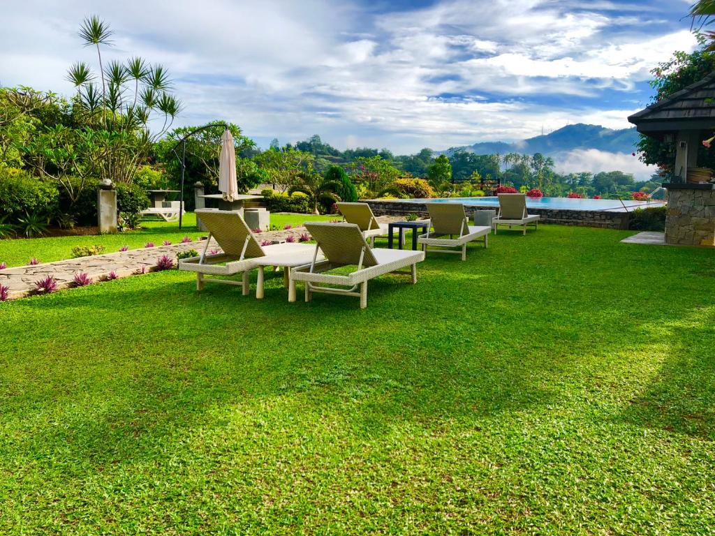 a group of lounge chairs sitting on a lawn at Elegant Hotel in Kandy