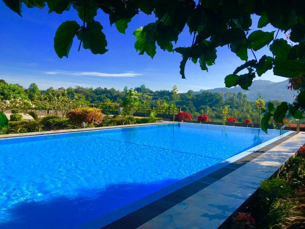 a swimming pool in a villa with blue water at Elegant Hotel in Kandy