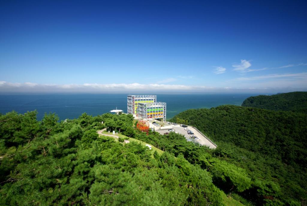 a building on top of a hill near the ocean at Haslla Art World Museum Hotel in Gangneung