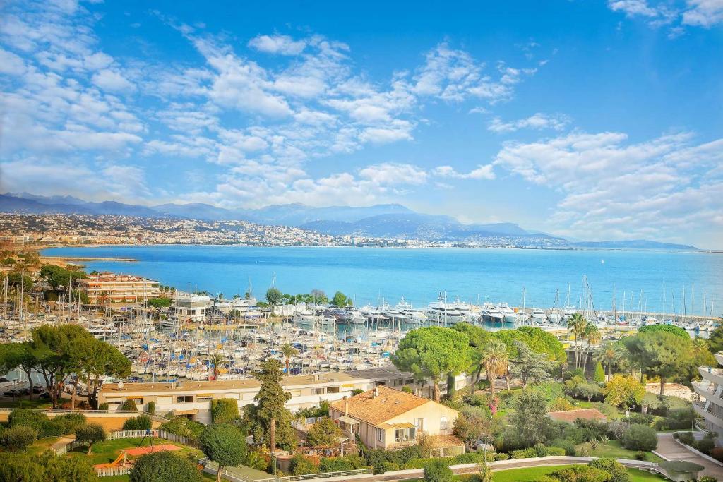 a view of a city and the water with boats at Vue Mer T2 Climatisé Marina Baie des Anges, étage 11, plages à 100 m in Villeneuve-Loubet
