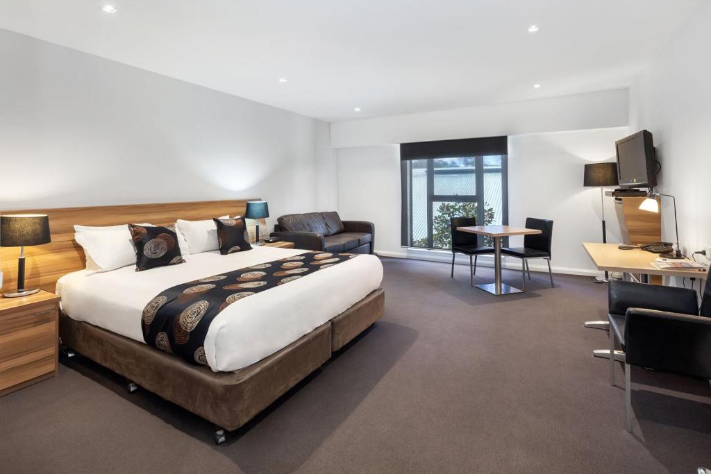 ein Hotelzimmer mit einem großen Bett und einem Schreibtisch in der Unterkunft Best Western Plus Ballarat Suites in Ballarat