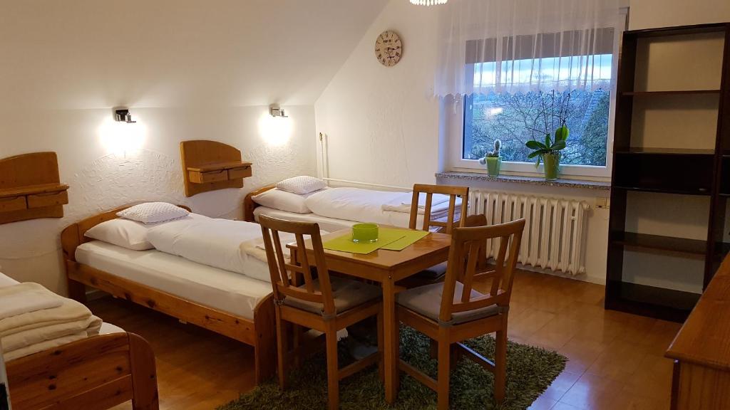 ブンツラウにあるEliza noclegiのベッド、テーブル、椅子が備わる客室です。