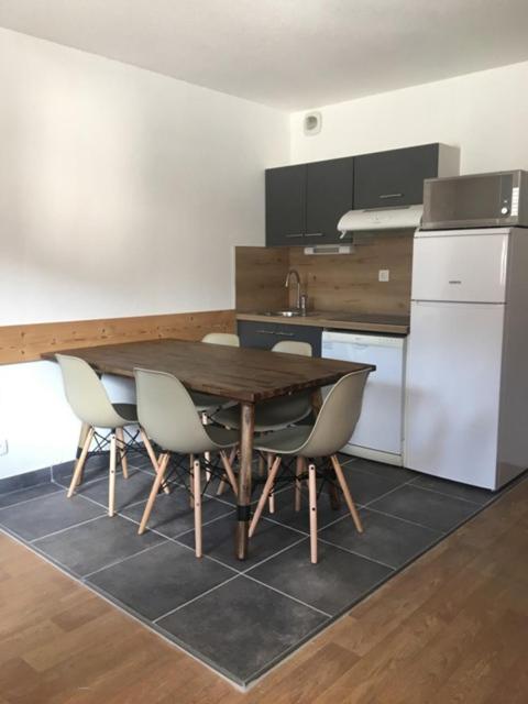 une cuisine avec une table et des chaises en bois dans l'établissement Appartement Flocon, 2 chambres, à Saint-Sorlin-dʼArves