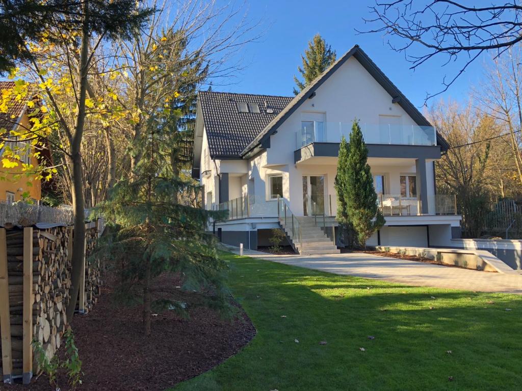 a large white house with a yard at Green Buda Valley: Holiday home with garden in Budapest