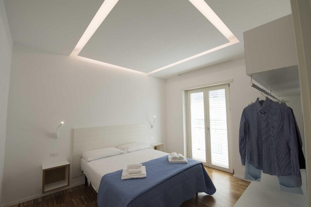 a white bedroom with a bed and a window at apARTments Sperlonga in Sperlonga