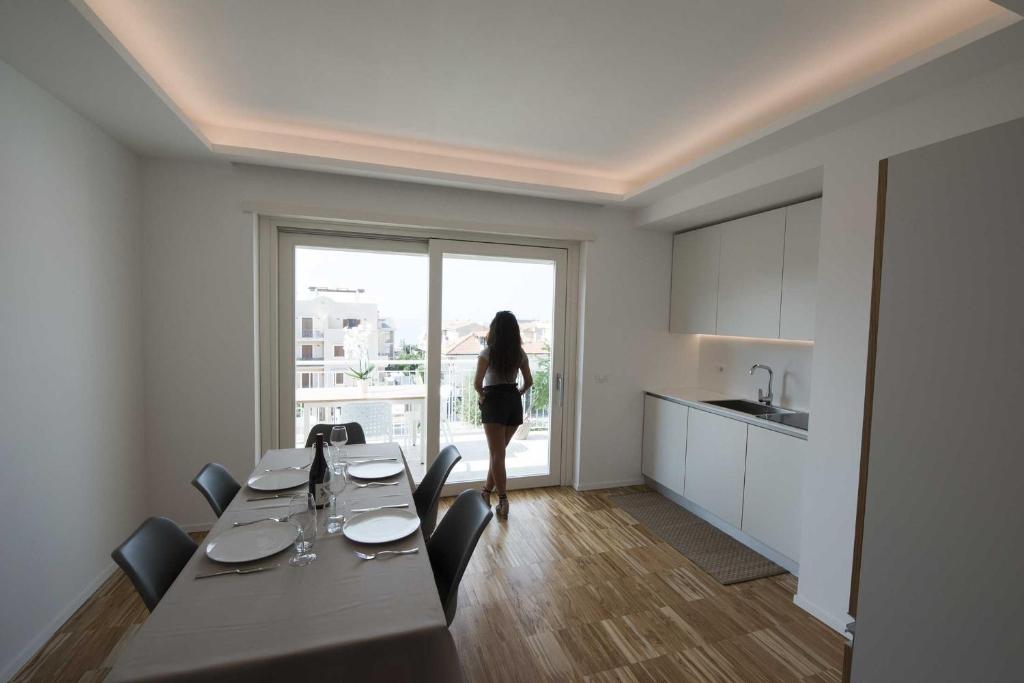 a woman standing in front of a table in a kitchen at apARTments Sperlonga in Sperlonga