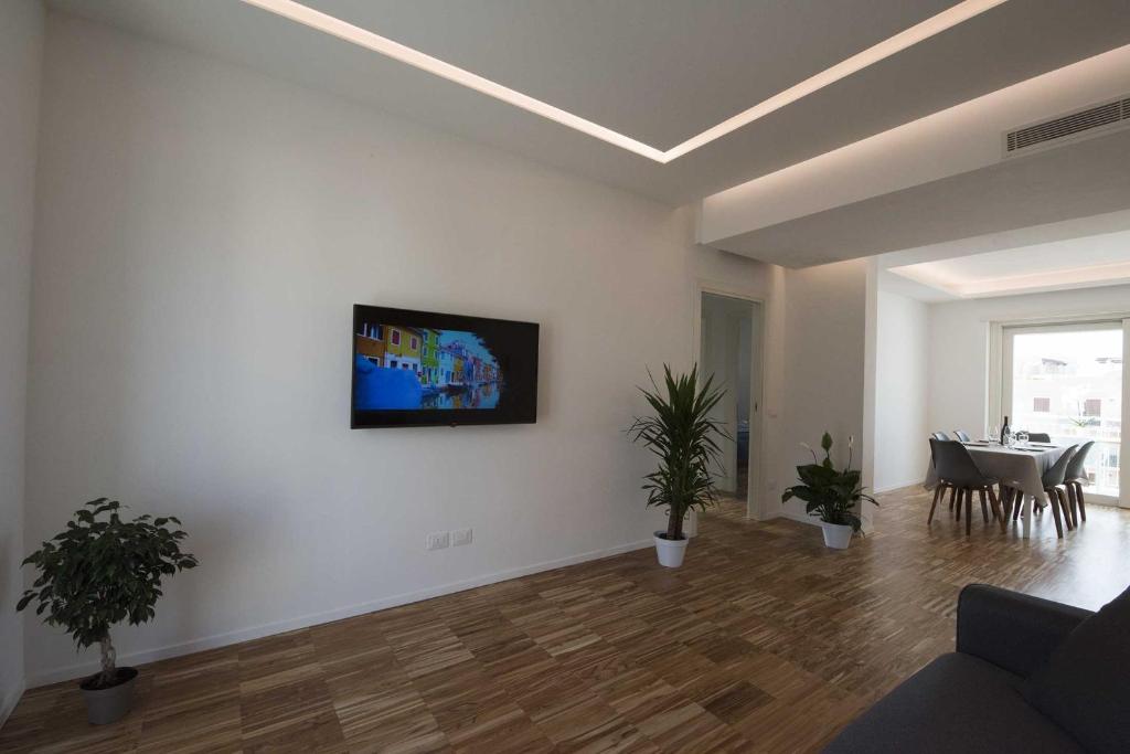 a living room with potted plants and a tv on a wall at apARTments Sperlonga in Sperlonga