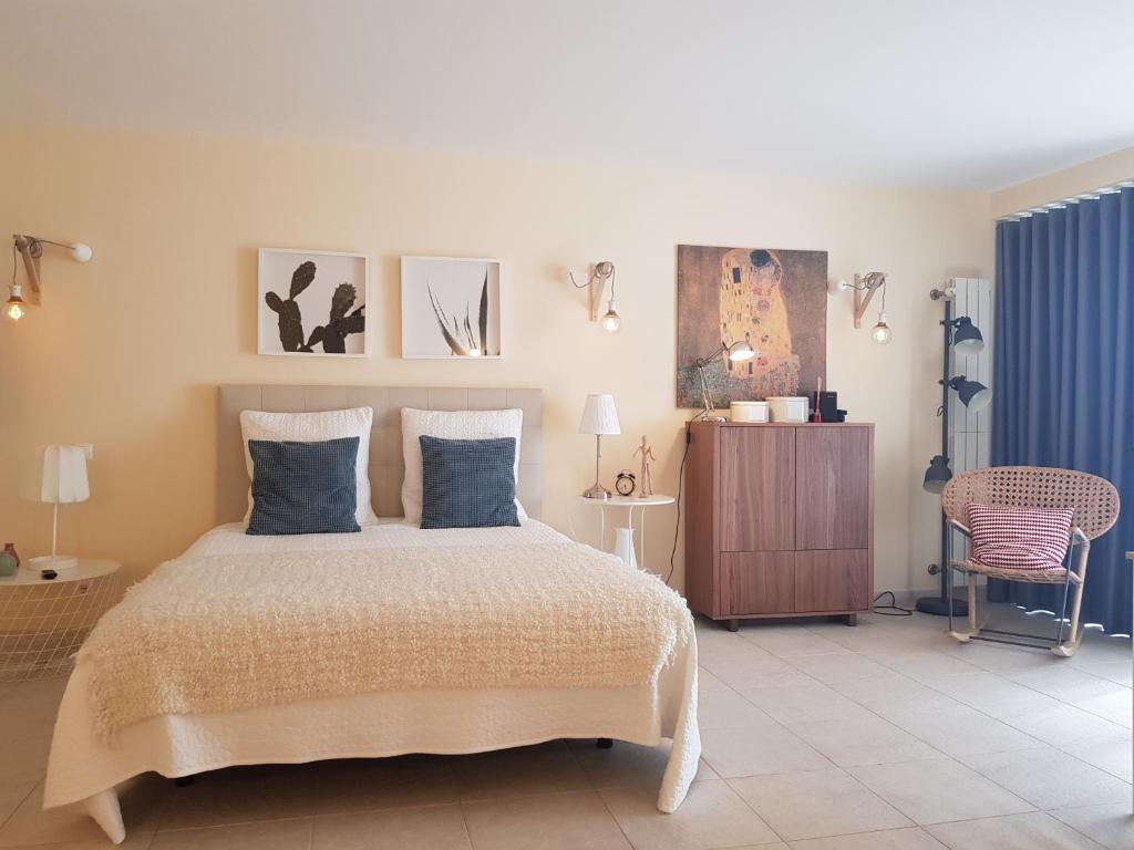 een slaapkamer met een groot bed en een stoel bij Cabanas Apartments Sea View in Cabanas de Tavira