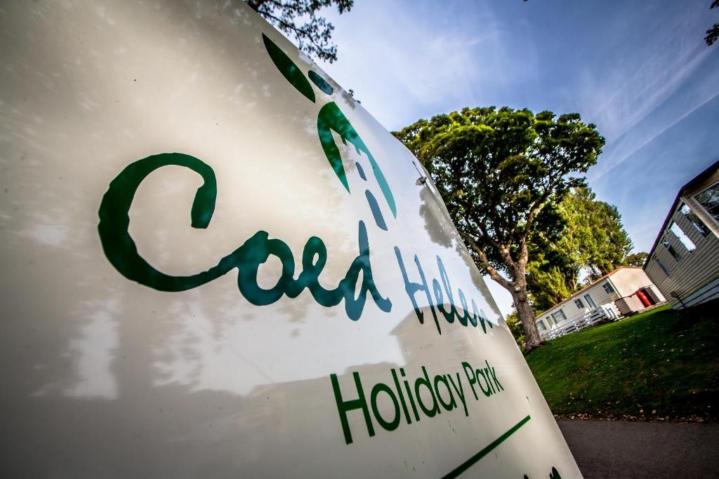 una señal con las palabras escritas en ella en Coed Helen Holiday Park, en Caernarfon
