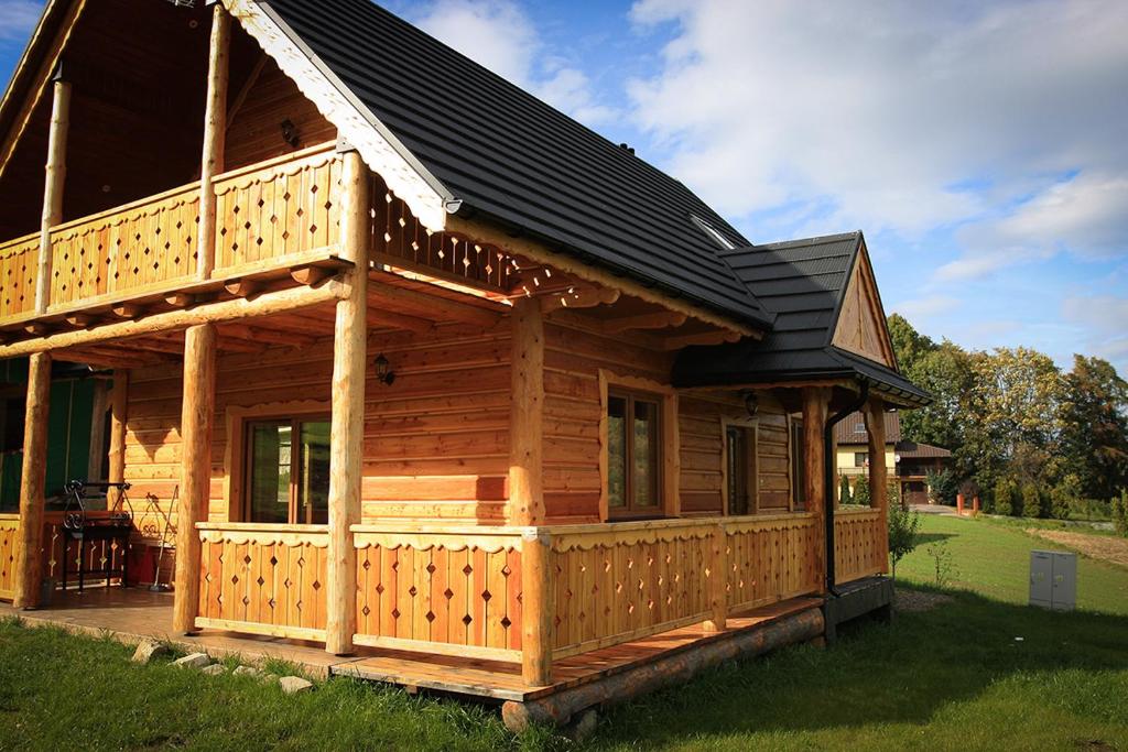 a large wooden cabin with a black roof at Noclegi Urbaniak in Tylmanowa