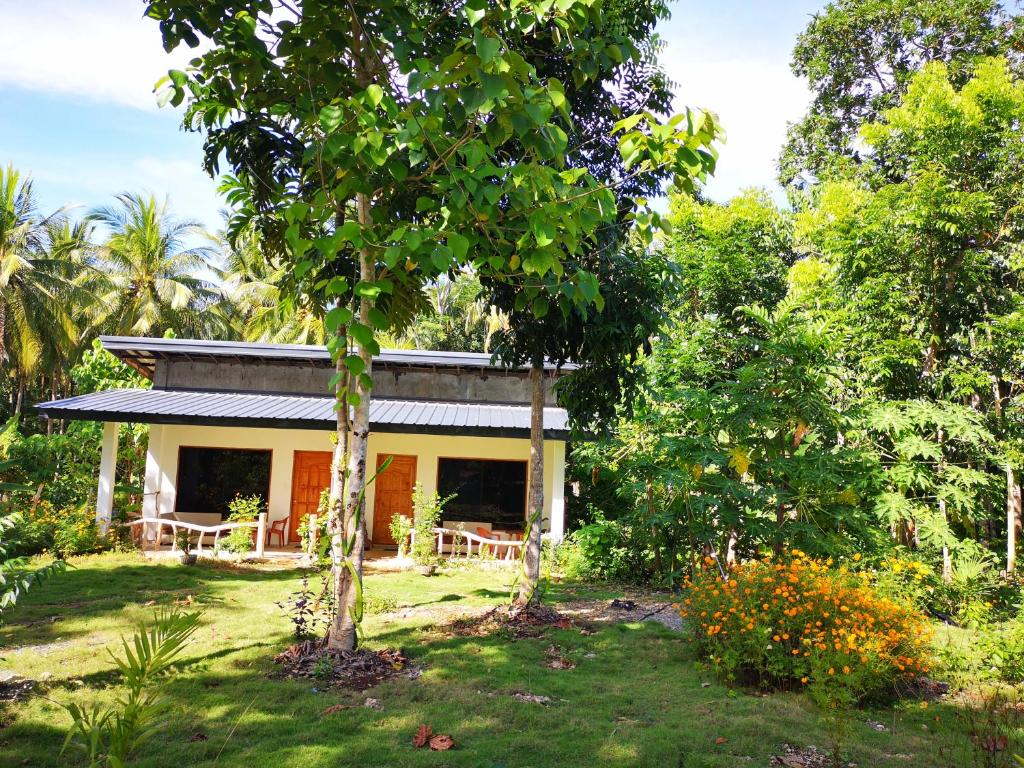a small yellow house in the middle of trees at Andnindot garden resort in Anda