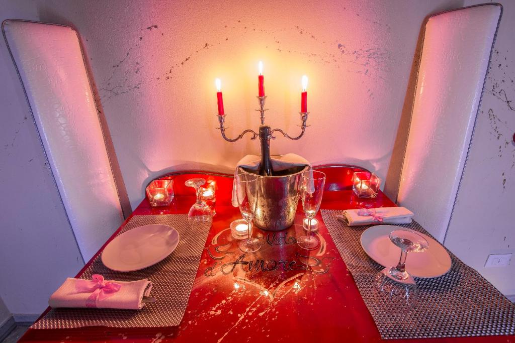 a table with two plates and candles on a table at Hotel Butterfly in Torre del Lago Puccini