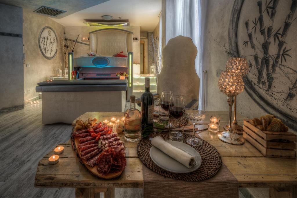 a table with a plate of food and glasses of wine at Hotel Butterfly in Torre del Lago Puccini
