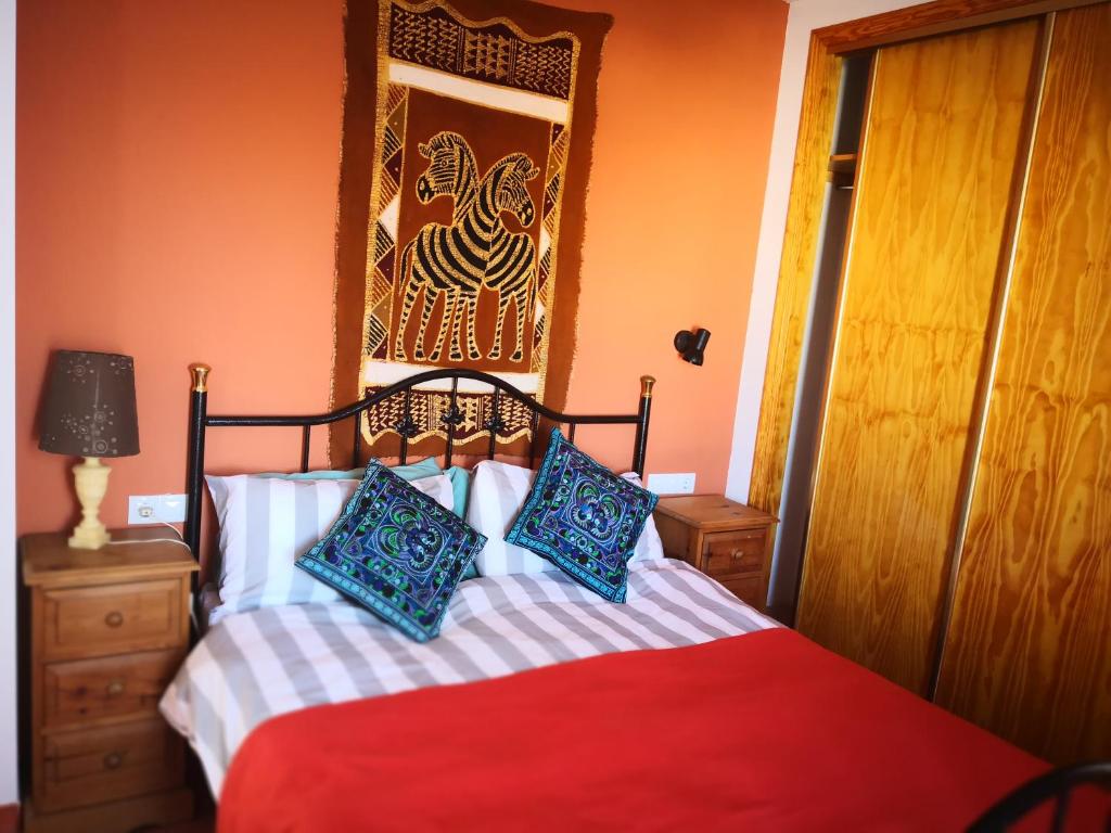 モハカルにあるJoya del Marのベッドルーム1室(青と赤の枕が備わるベッド1台付)