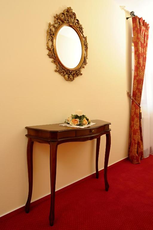 a table with a mirror and a red carpet at Hotel U Krále in Jičín