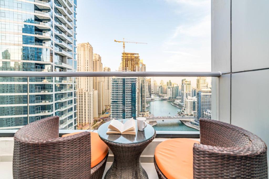 a table and chairs on a balcony with a view of a city at Icon Casa Living - Bay Central Tower in Dubai