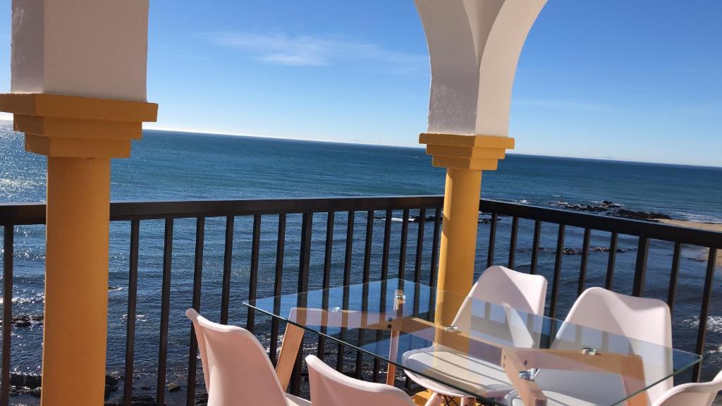 een balkon met een tafel en stoelen en de oceaan bij BALCON DEL MAR 2-3 A, APARTAMENT ON THE BEACH FRONT in La Cala de Mijas