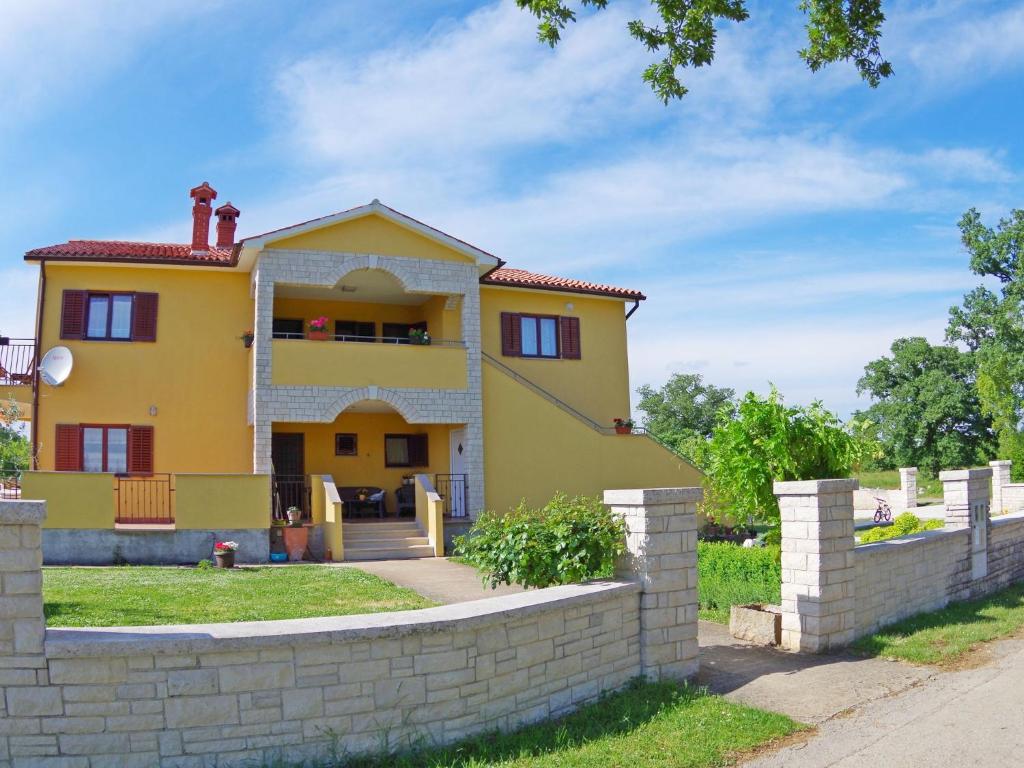 a yellow house with a brick wall at Premium Apartment in Barban with Private Pool in Šajini