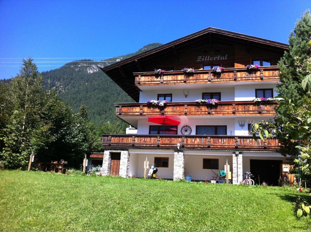 ein Gebäude mit Blumen auf den Balkonen in der Unterkunft Haus Zillertal am Achensee in Maurach