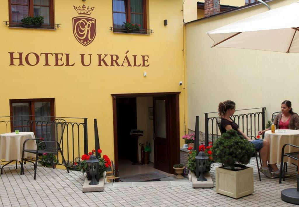 two people sitting at tables in front of a hotel ukiane at Hotel U Krále in Jičín